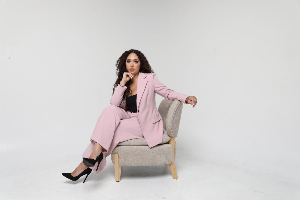 Founder of Attorney Support Solutions seated in a pink suit
